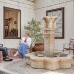 Two people sitting outside on patio with fountain at Santé