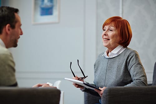 Red haired woman talking to man in detox center