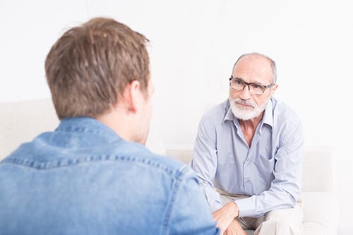 Older and younger men talking a mens drug rehab.