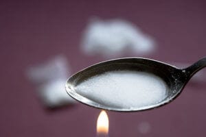 Cooking heroin in a spoon before injection is a definite sign of heroin abuse.