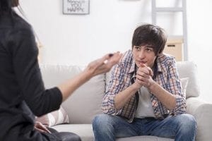 A female counselor talks to a male teenager about teen drug abuse
