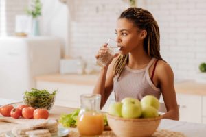 woman sipping glass of water at alcohol detox