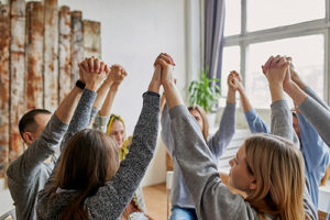 group raising held hands at xanax addiction treatment
