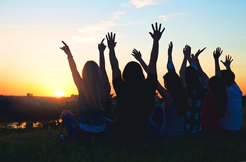 people in an alumni program celebrate at sunset