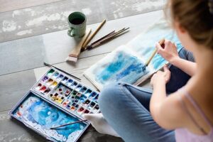 a woman paints as part of an art therapy program