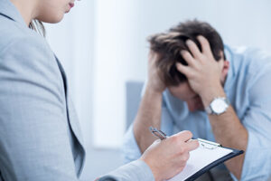 a man talks to a counselor in a purging disorder treatment program