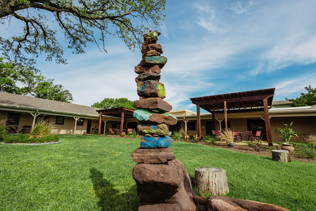 rock statue in front of building of sante center of healing