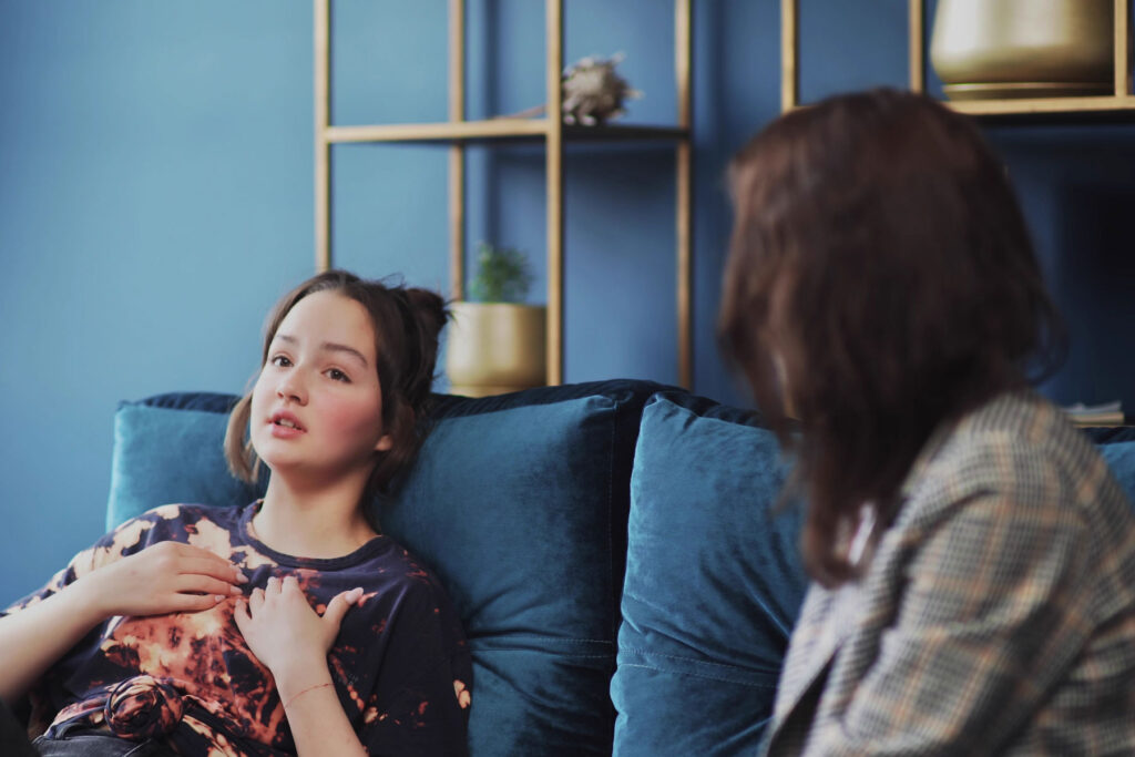 young woman engaging with bipolar disorder treatment with a therapist in an office setting.
