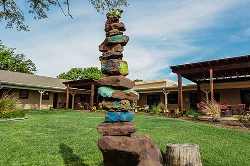 a rock scupture of colorol balanced stones in the courtyard of an addiciton treatment center offering holistic therapy
