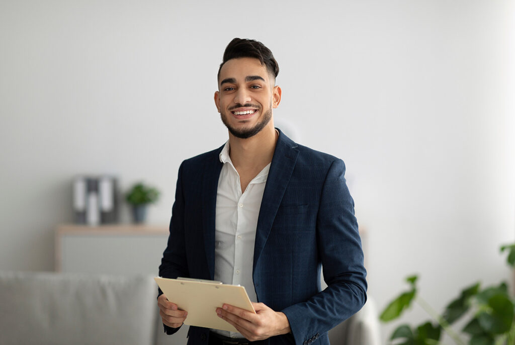 smiling young man in professional attire who has just completd a men's addiciton treatment program.