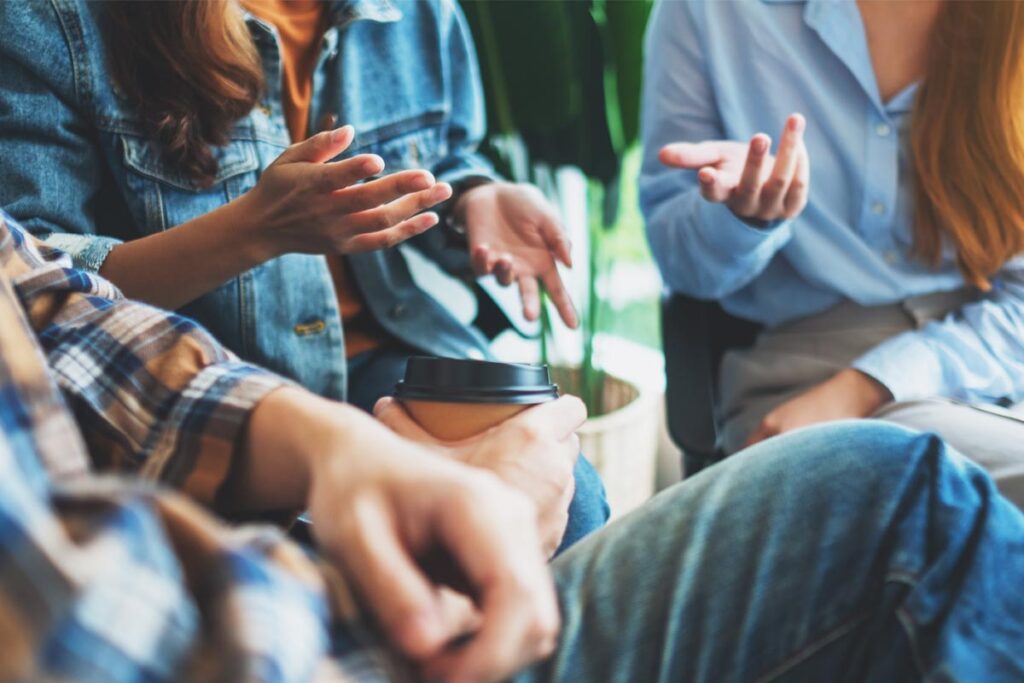 close up of the hands of people engaged in a group therapy session