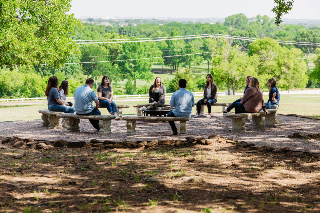 group of people seated outdoors on benches in beautiful scenic surroundings