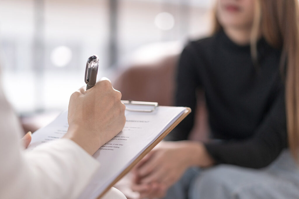therapist explaining the effects of fentanyl on the brain to a young woman in an office setting.