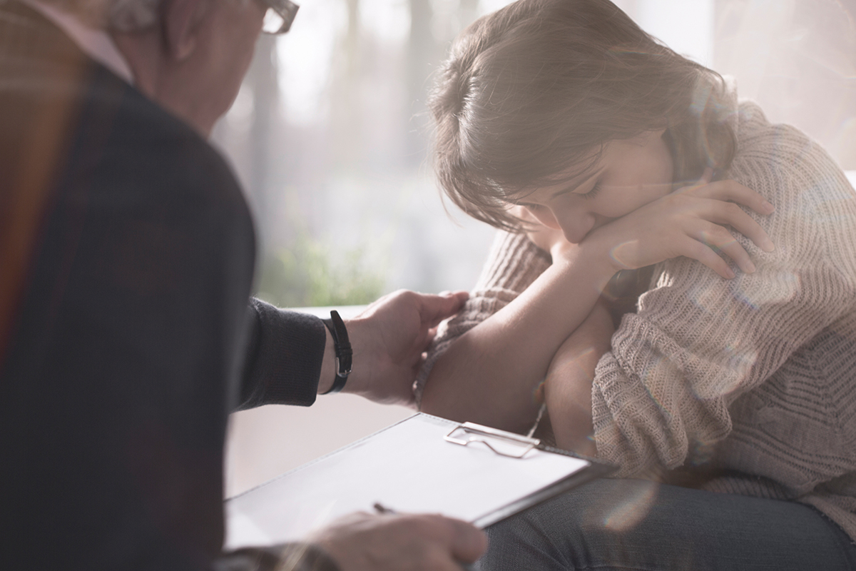 A teen is comforted by their therapist as they discover the trauma behind their addiction.